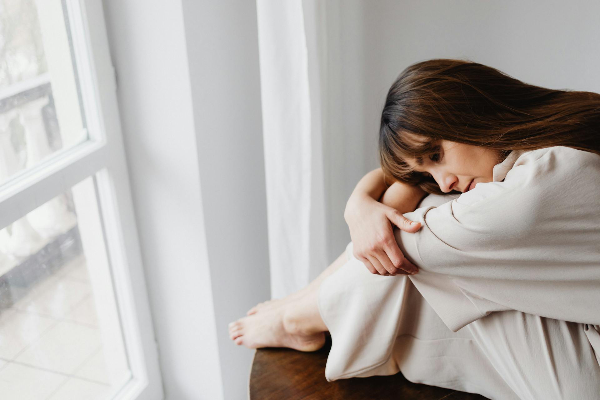 A distressed woman sitting by the window | Source: Pexels