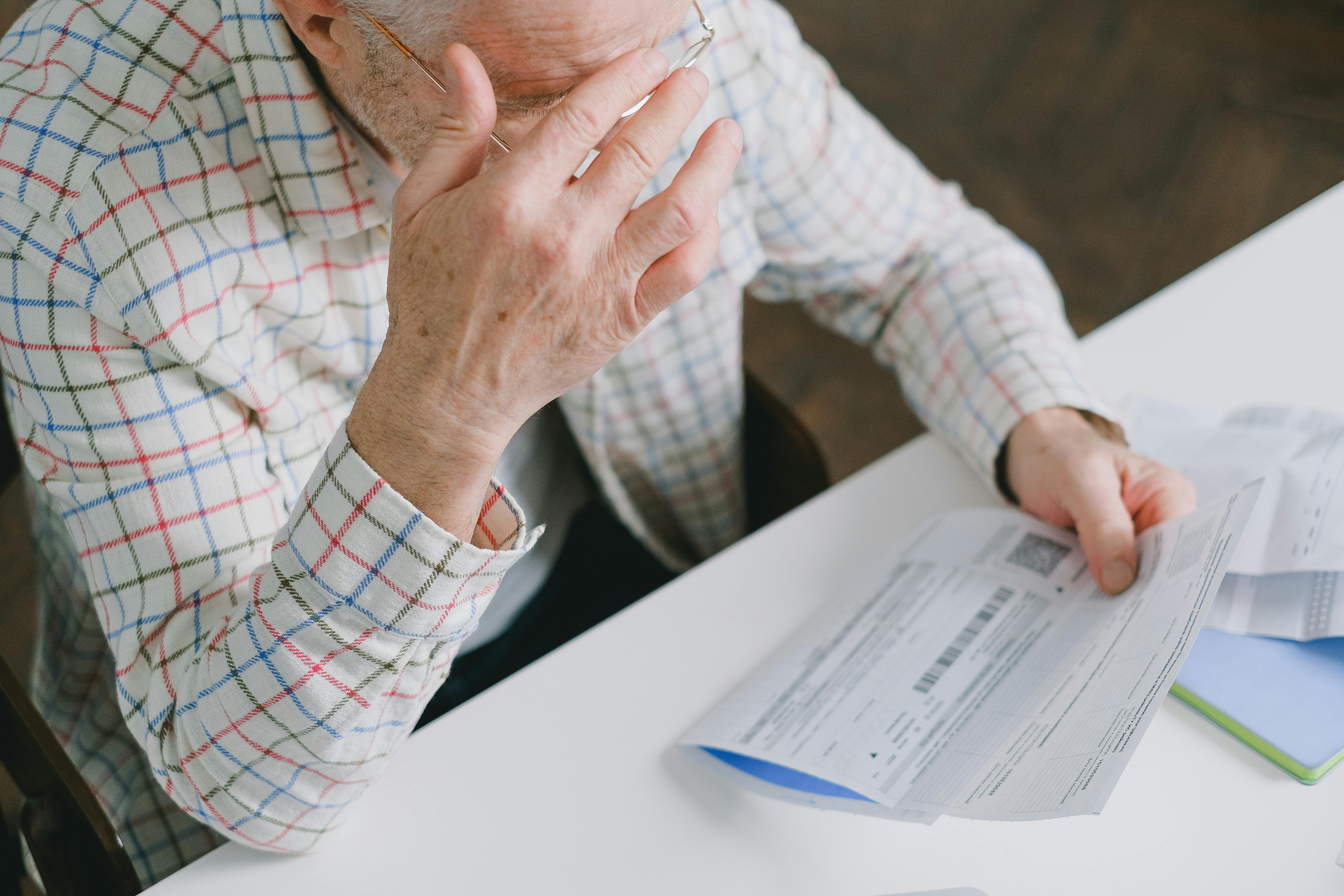 Elderly man holding a paper | Source: Pexels