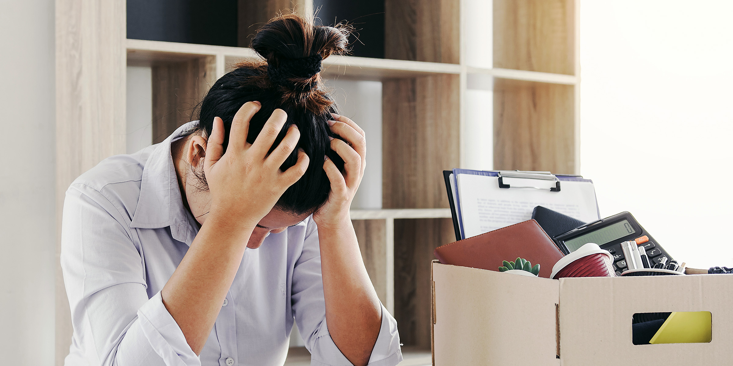 A stressed woman sitting in her office | Source: Shutterstock