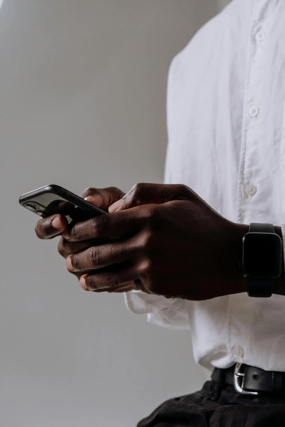 A man in a white shirt texting on his phone | Source: Pexels