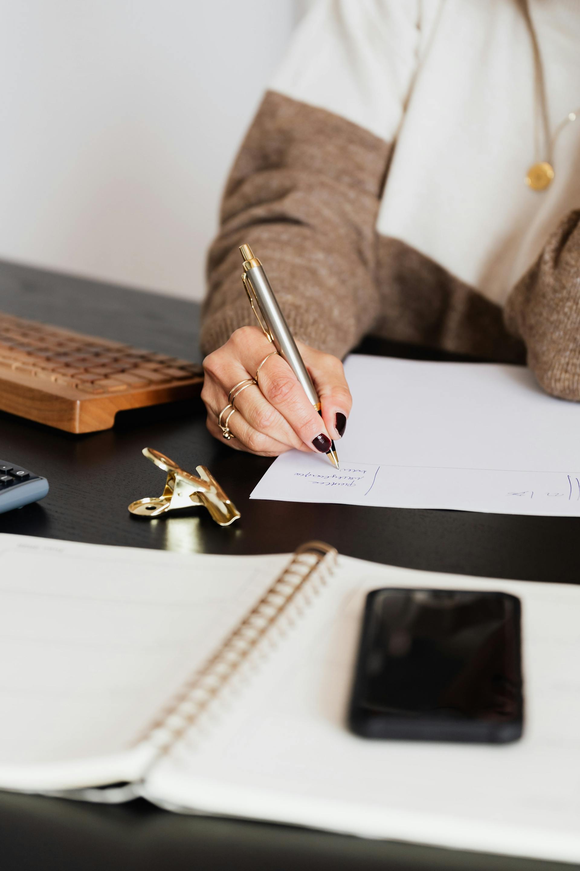 A woman writing on a paper | Source: Pexels