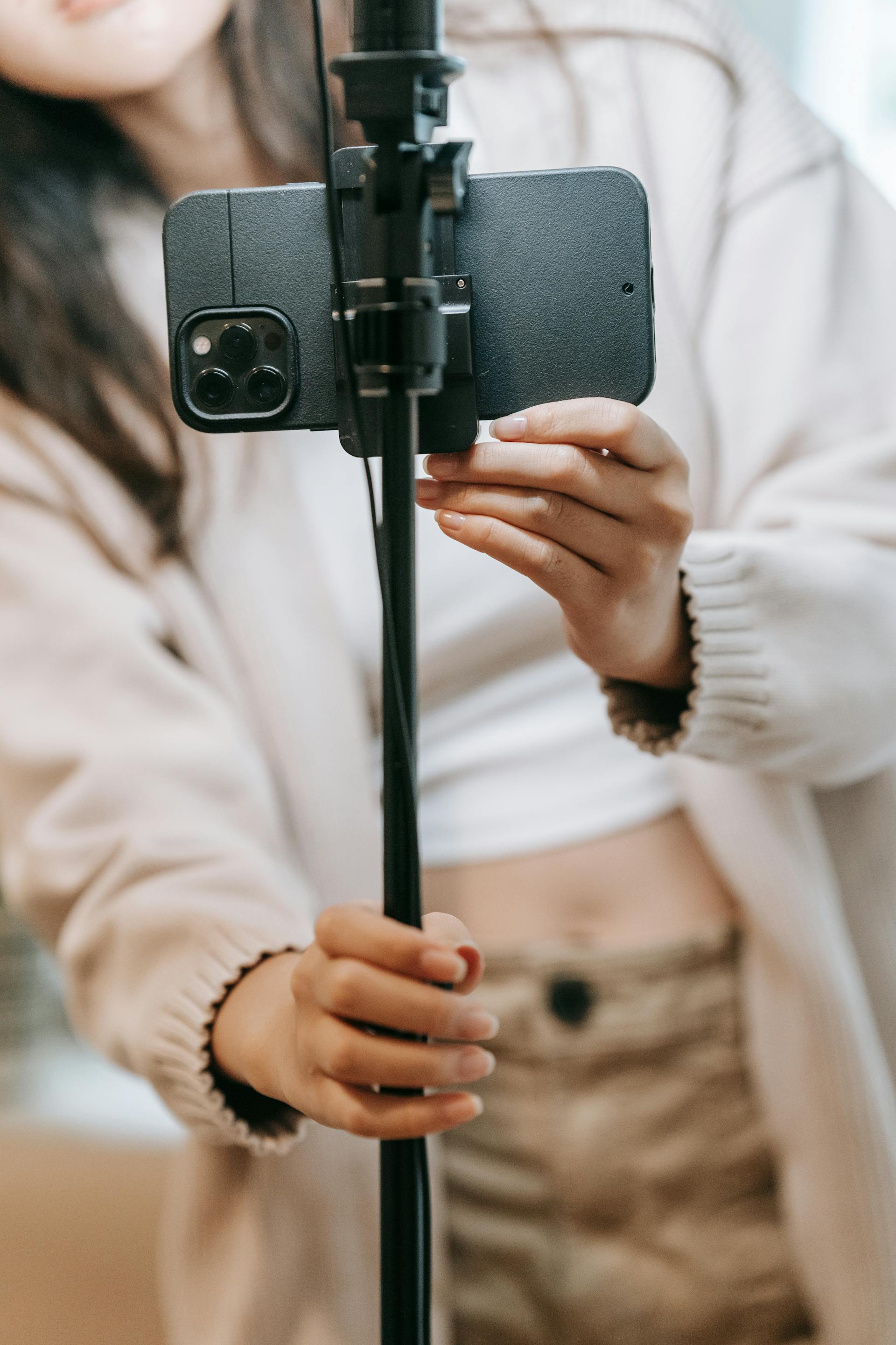 Someone holding a phone on a selfie stick | Source: Pexels