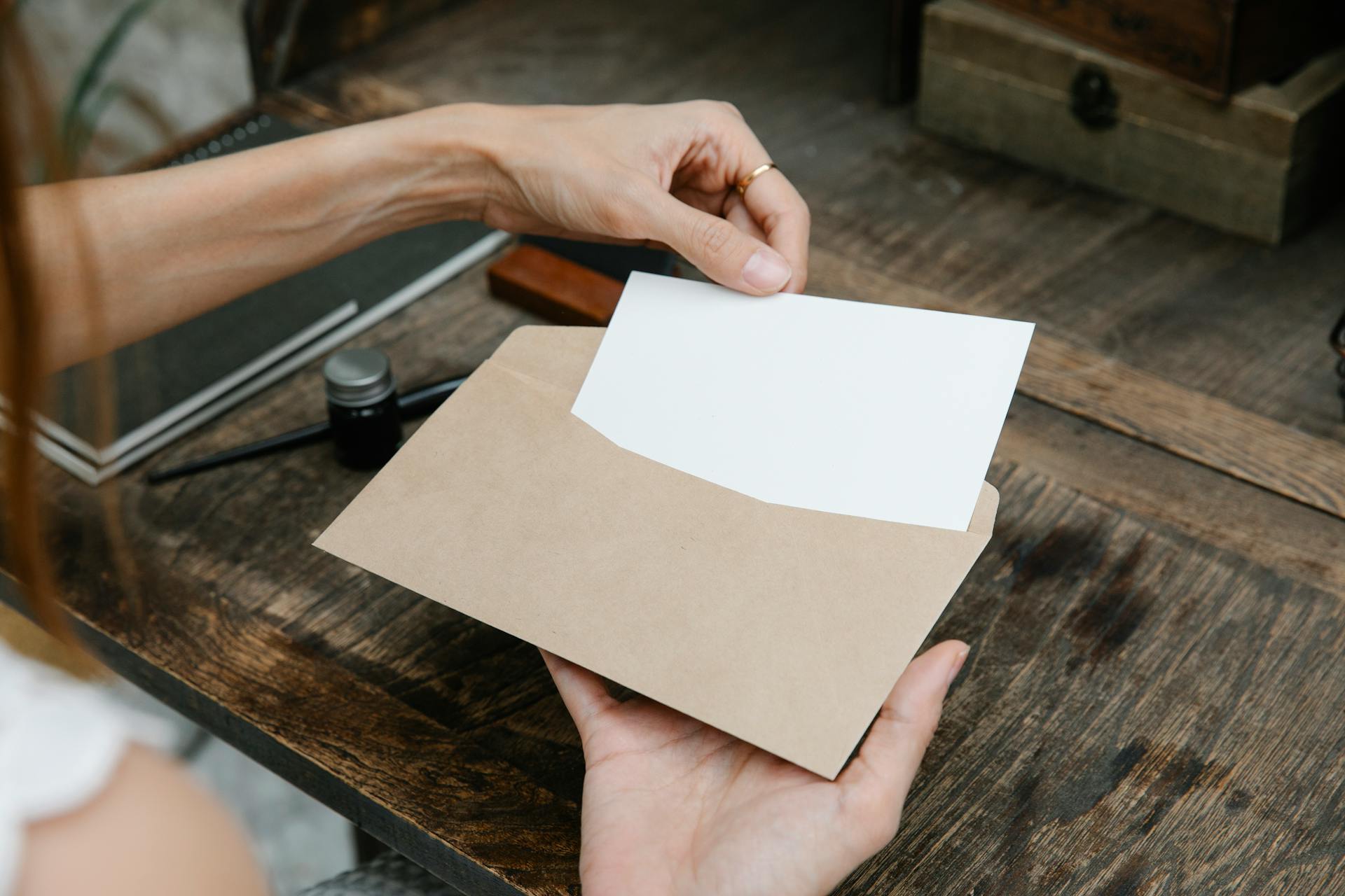 A woman pulling out a piece of paper from an envelope | Source: Pexels