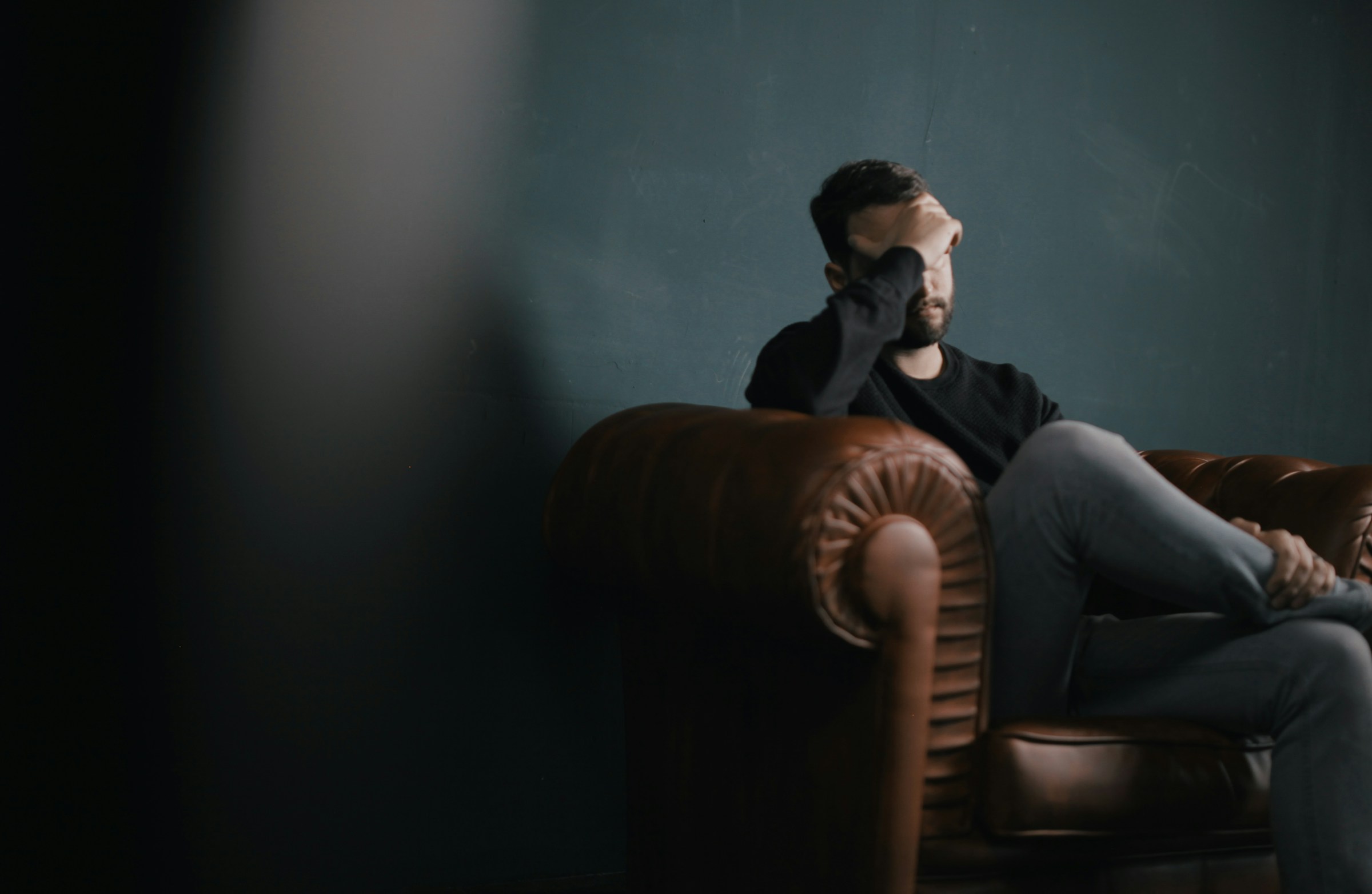 A man sitting with his hand on his head | Source: Unsplash