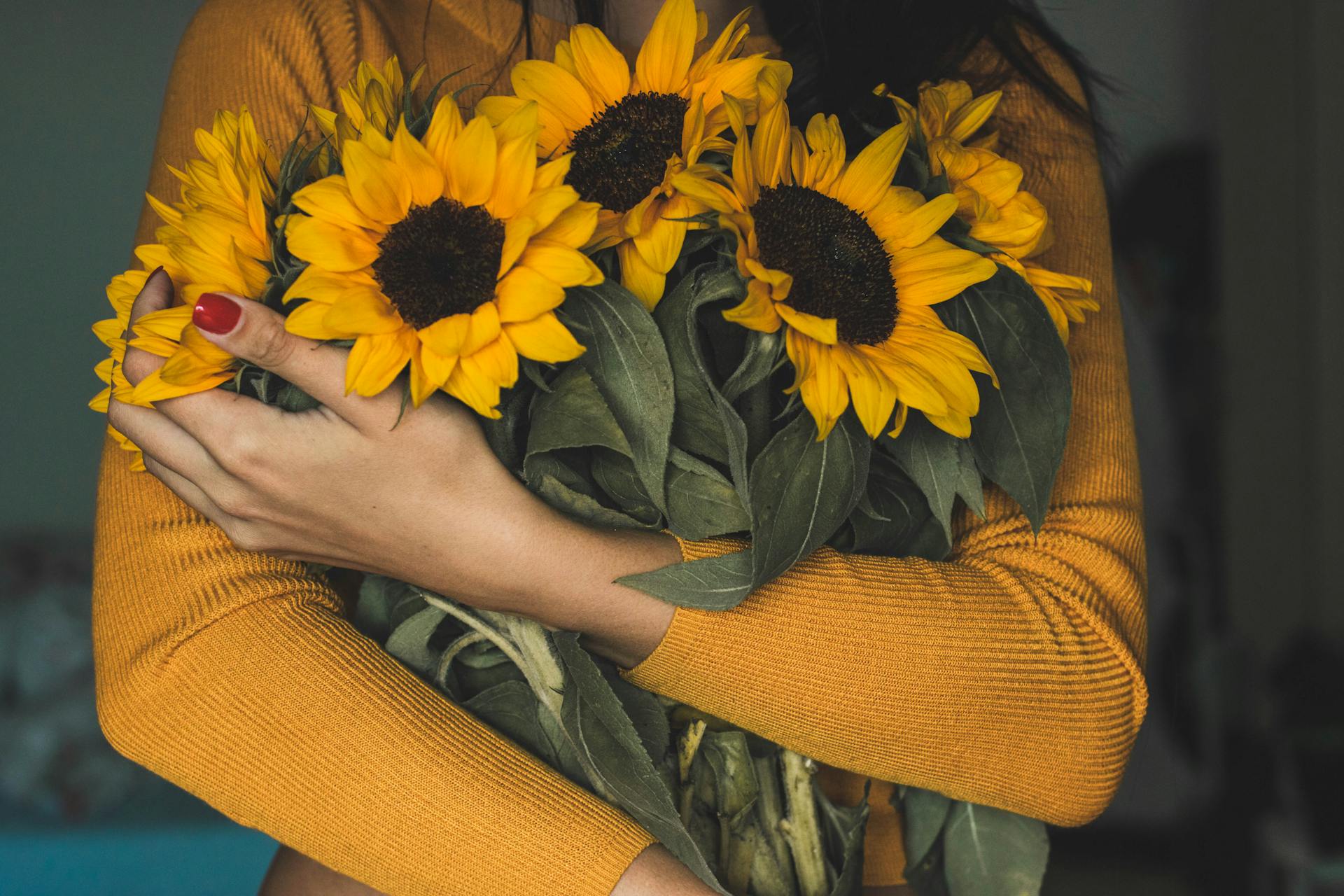 A woman holding a bunch of sunflowers | Source: Pexels