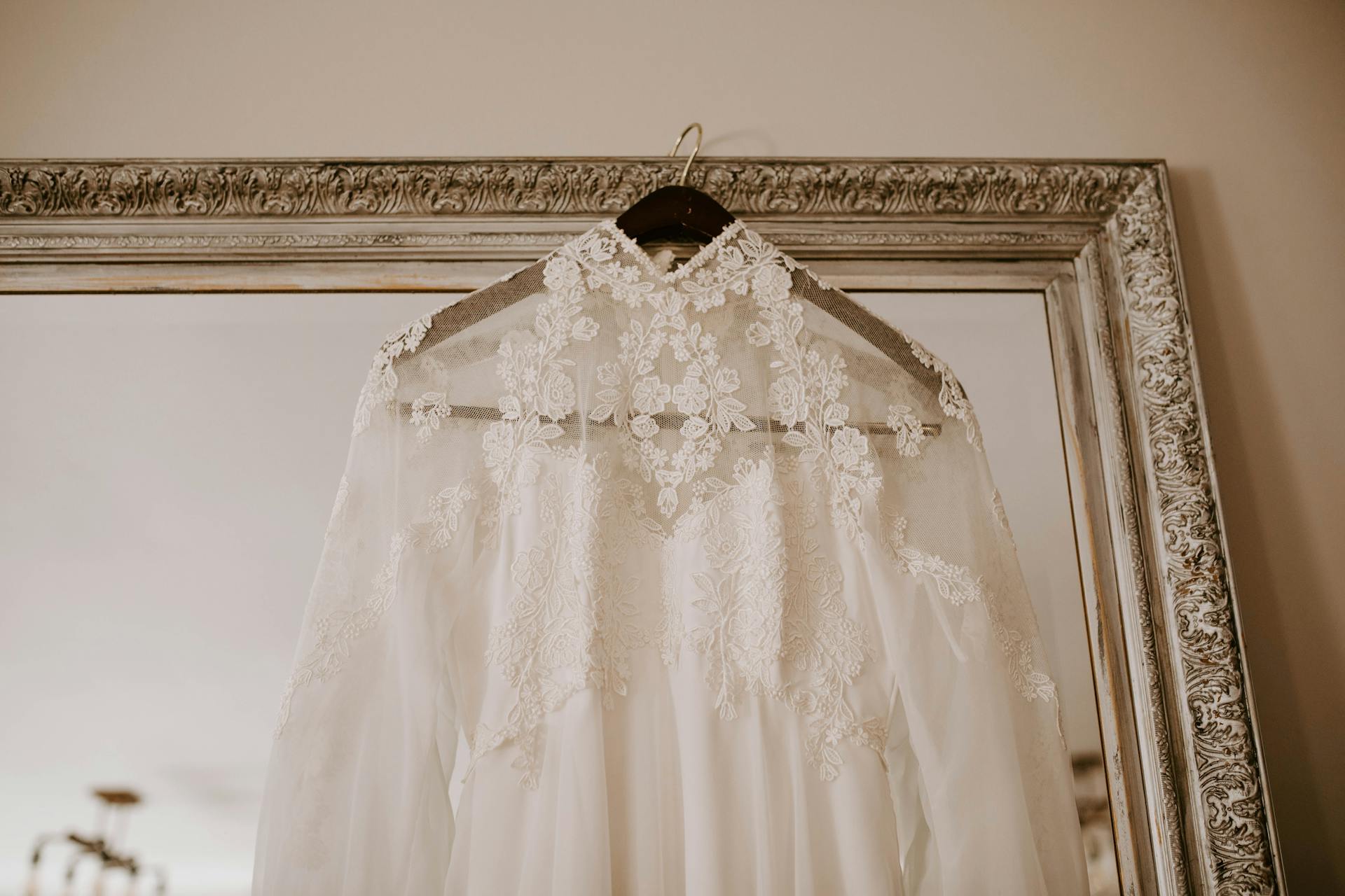 A wedding dress hanging on a mirror | Source: Pexels