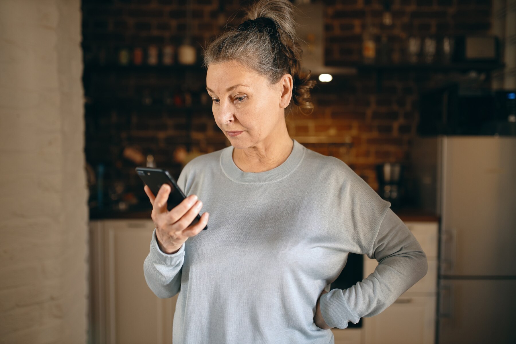 Uma mulher séria ao telefone | Fonte: Freepik