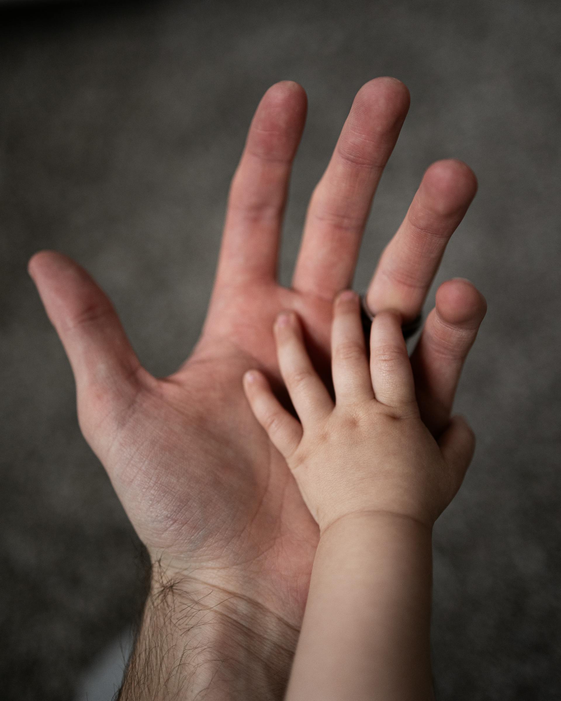 A man and baby's hands | Source: Pexels