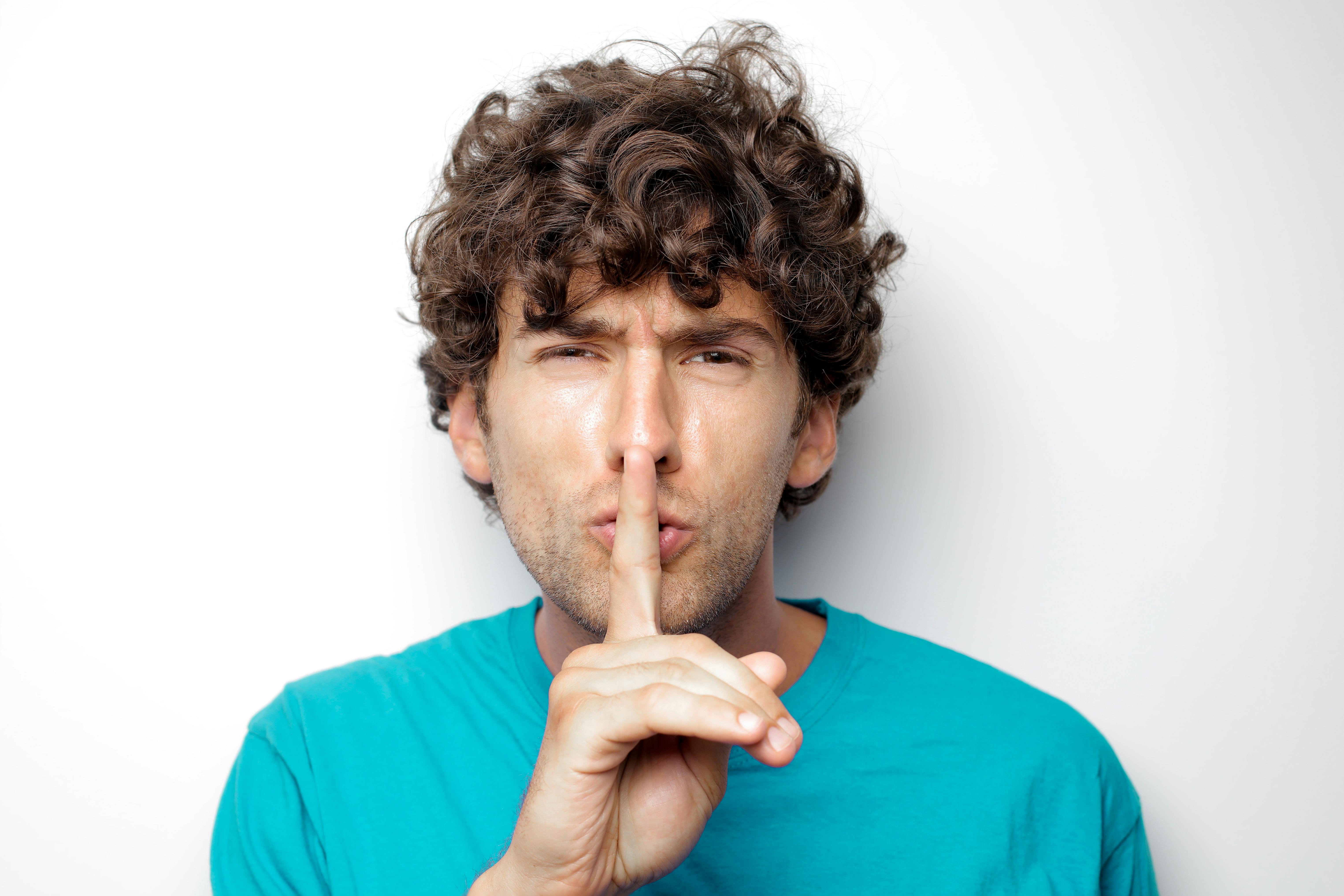 A man with a finger over his mouth | Source: Pexels
