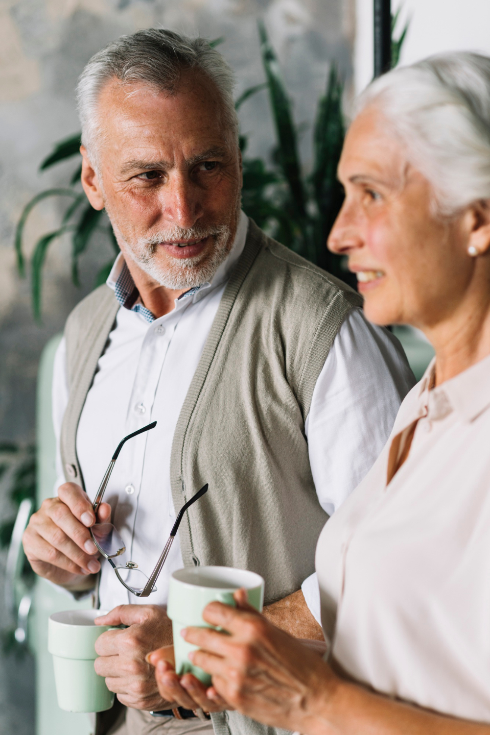 A delighted senior couple standing beside each other | Source: Freepik