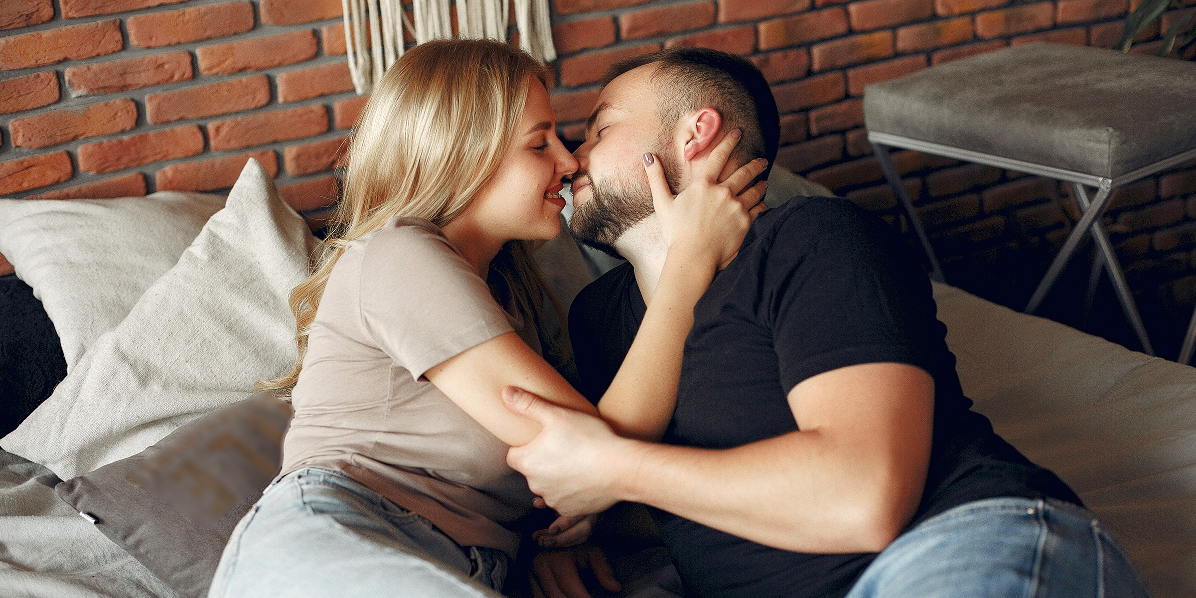 A romantic couple lying on the couch and holding each other | Source: Freepik