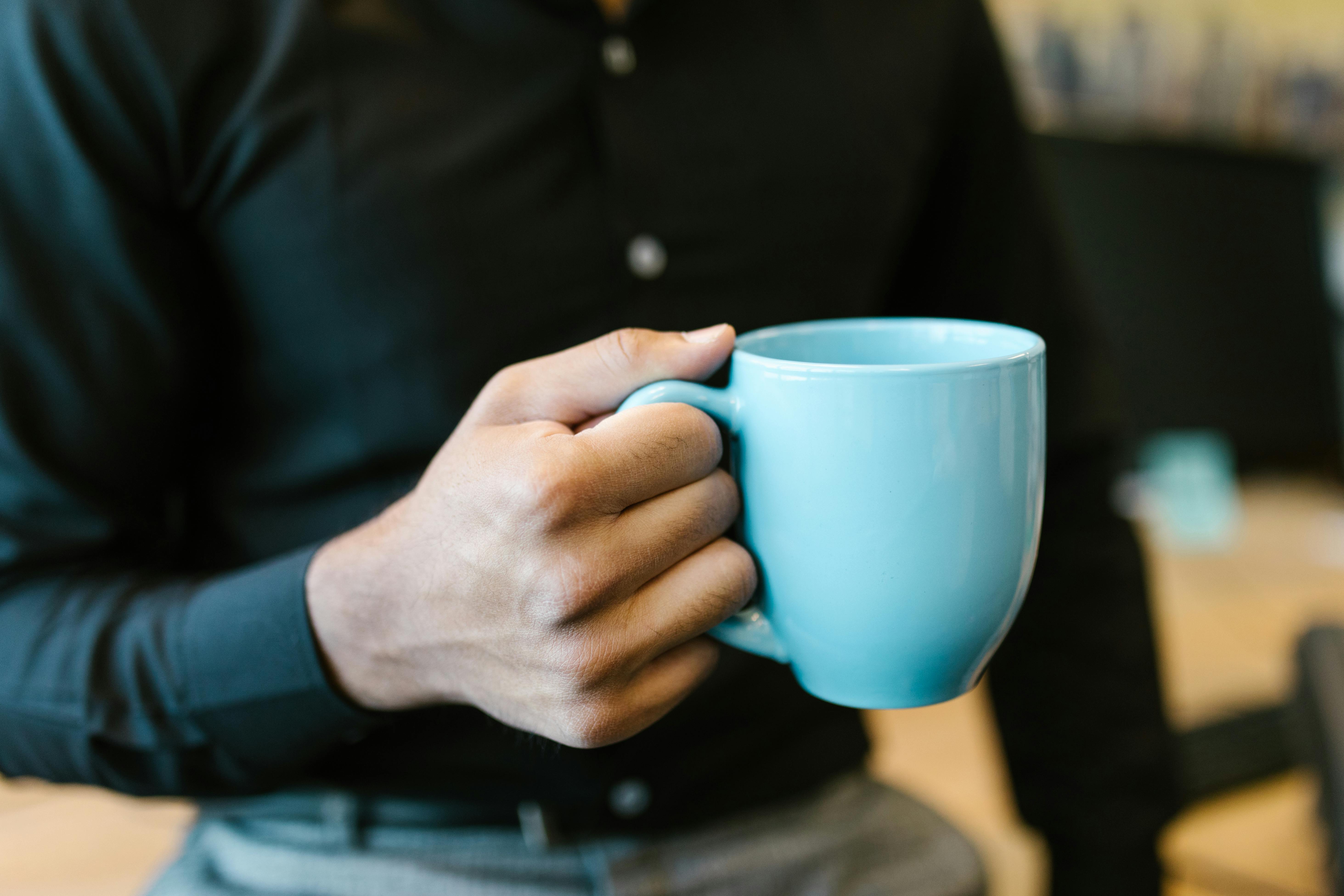 A person holding a ceramic mug | Source: Pexels