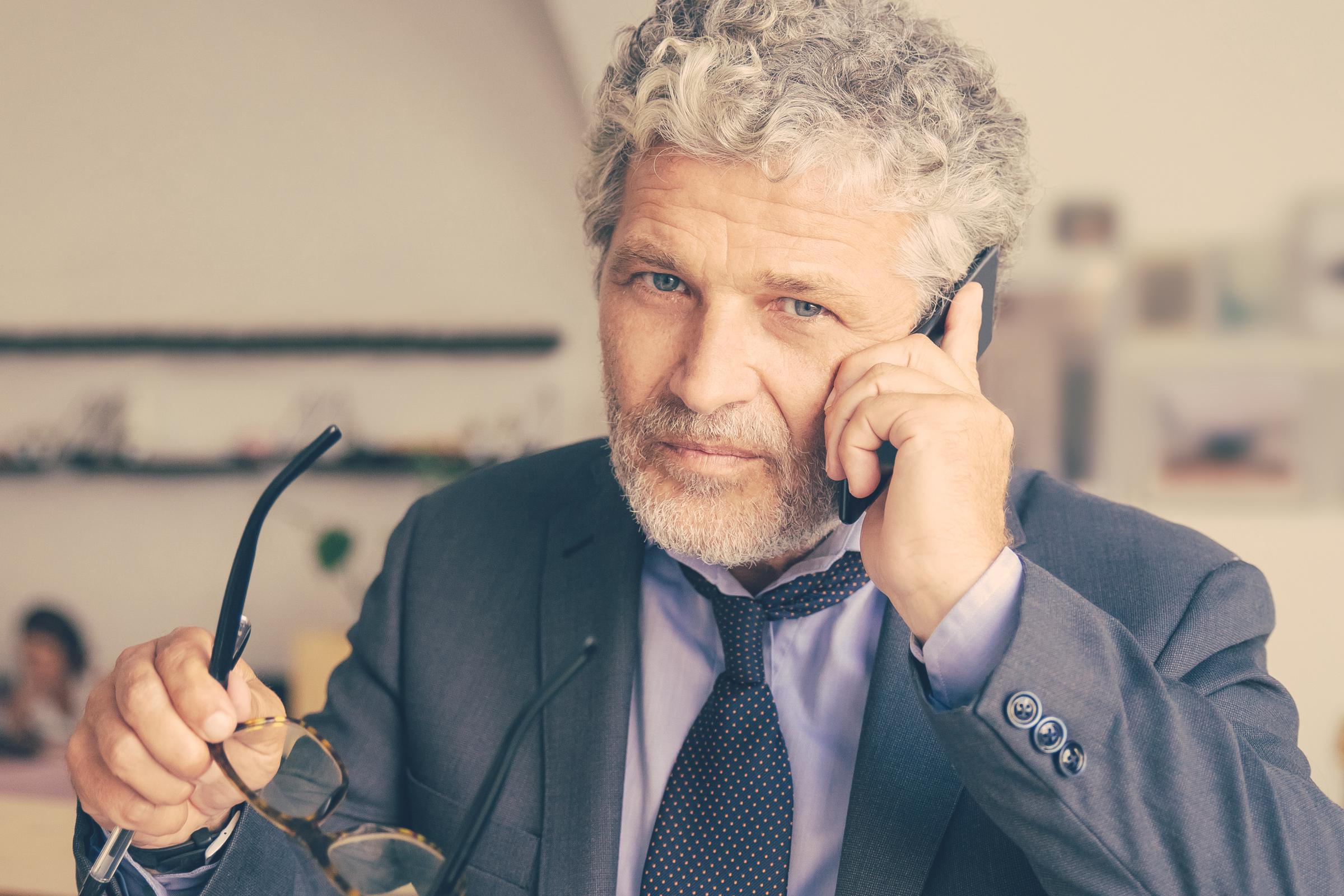 A serious man on a call | Source: Freepik
