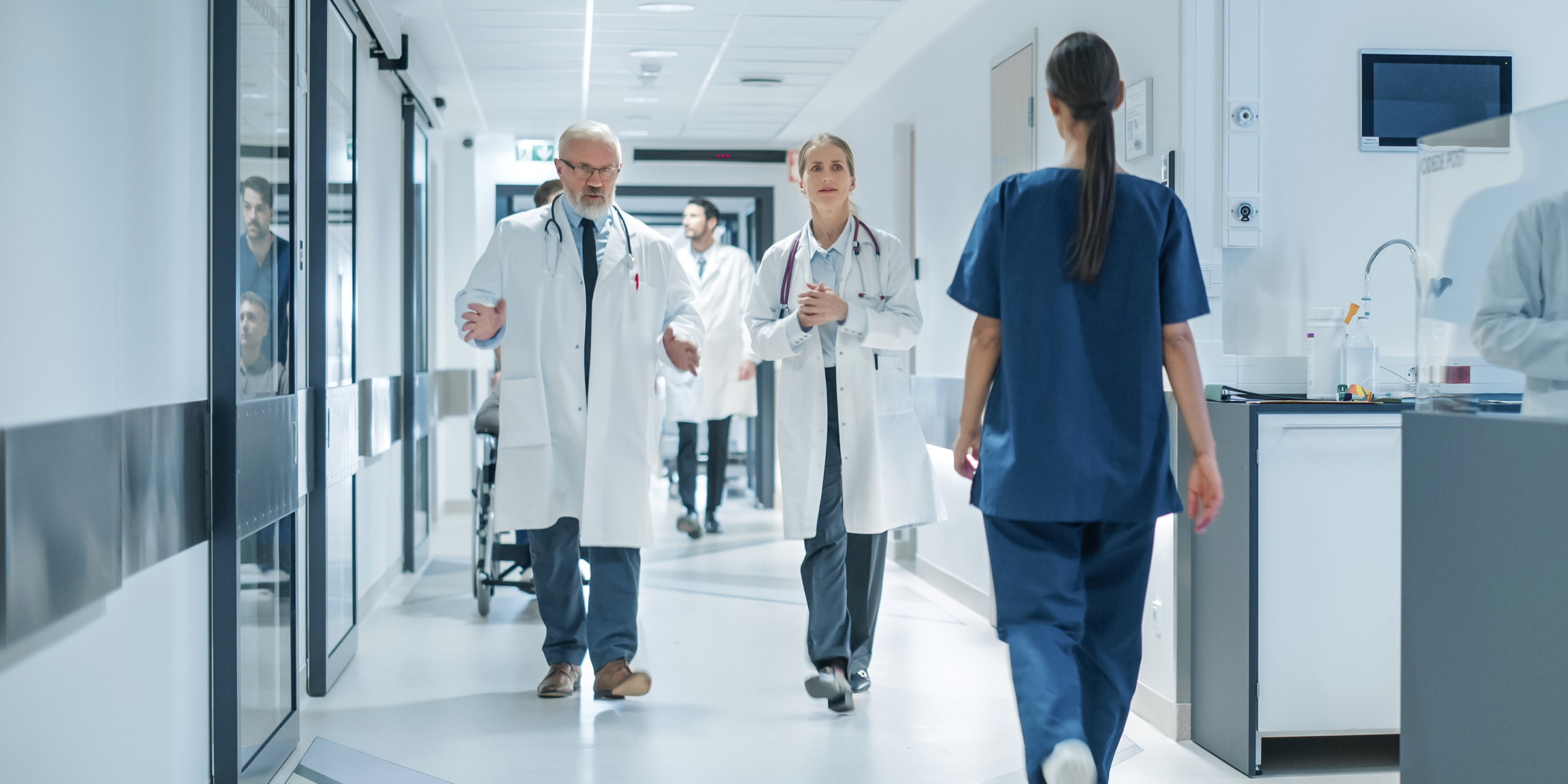 Doctors and medical staff walk through a brightly lit hospital corridor during a busy shift | Source: Shutterstock
