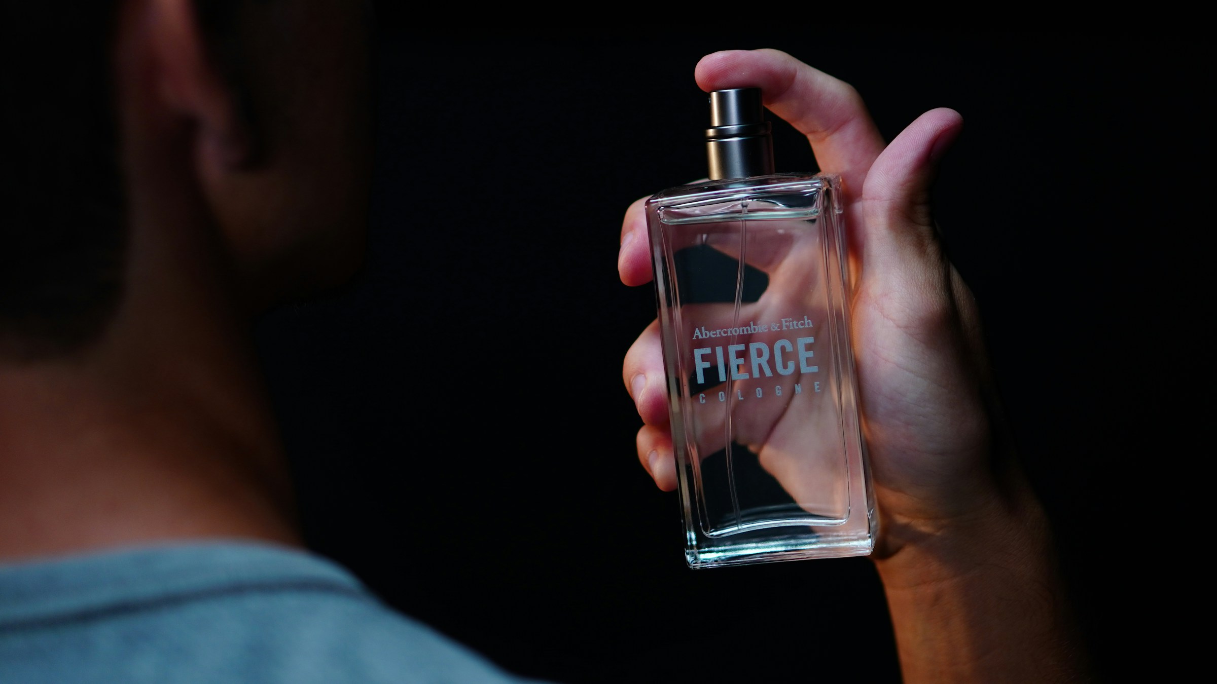 Close-up shot of a man holding a perfume bottle | Source: Unsplash