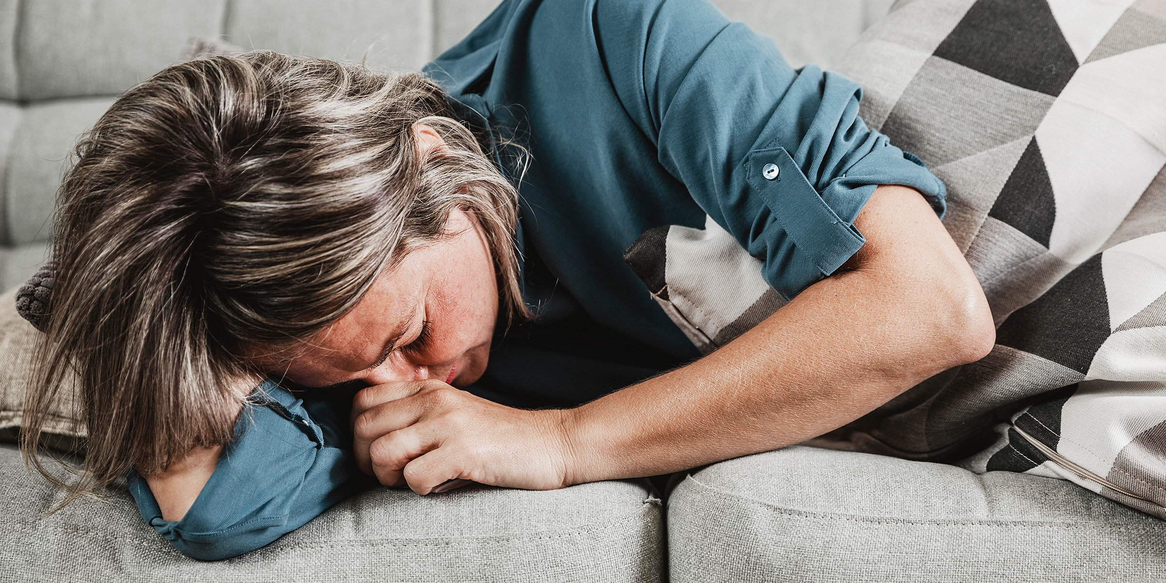 A miserable woman crying on a couch | Source: Freepik