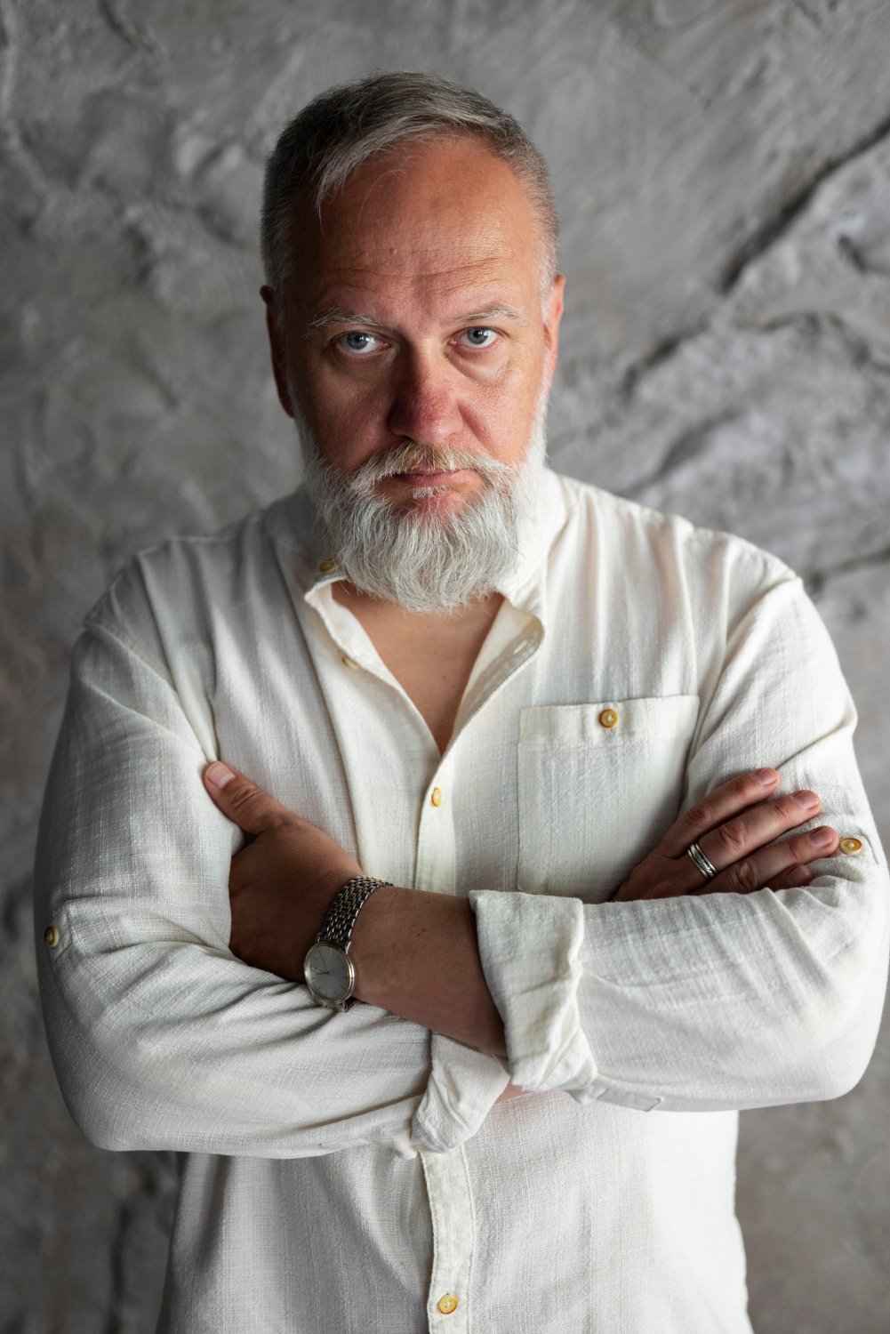 A frustrated senior man with his arms crossed | Source: Freepik