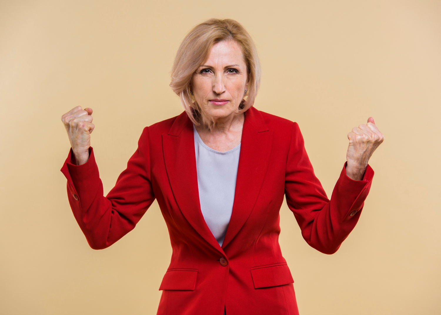 An angry senior woman clenching her fists | Source: Freepik