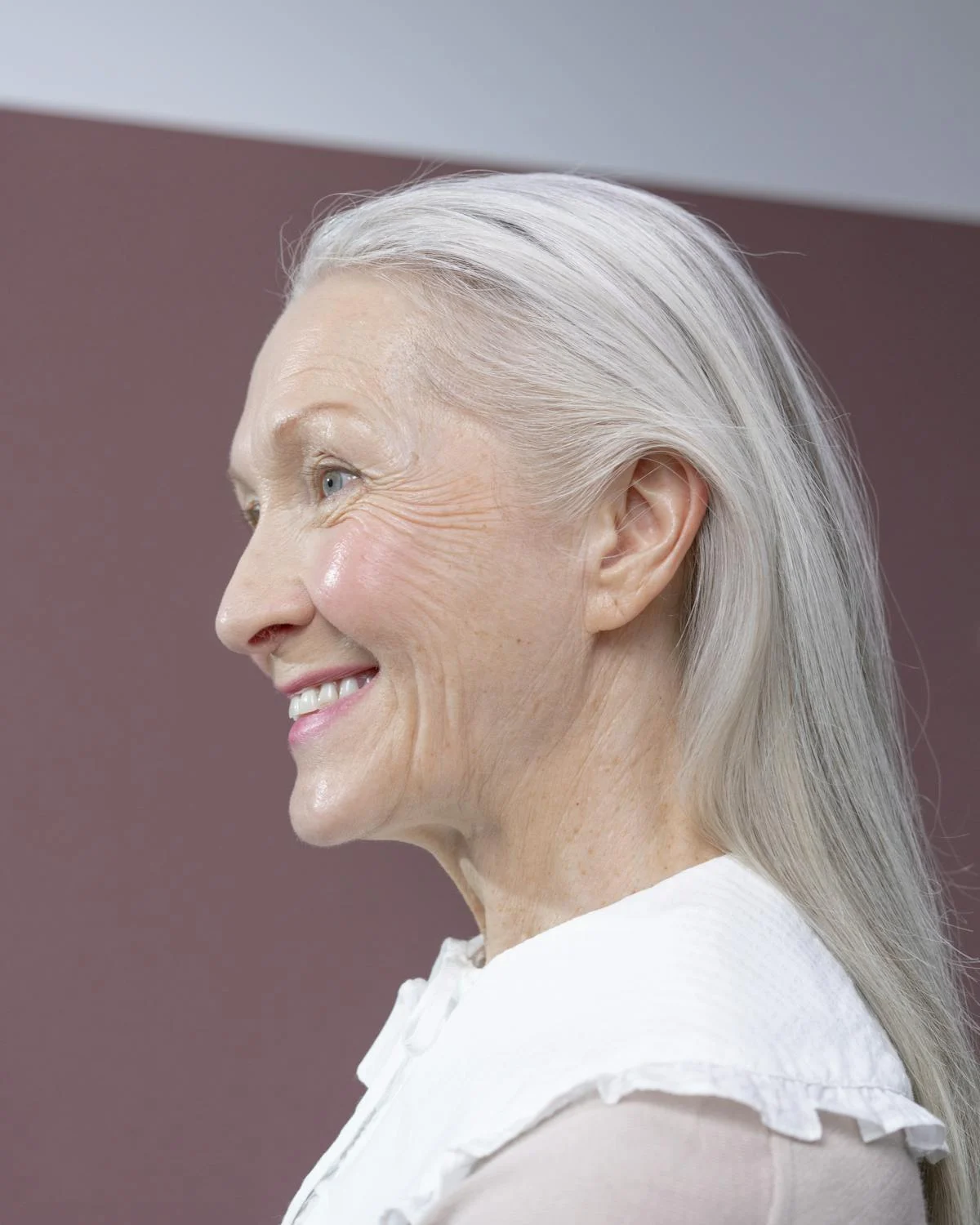 Uma foto lateral de uma mulher madura sorridente | Fonte: Pexels