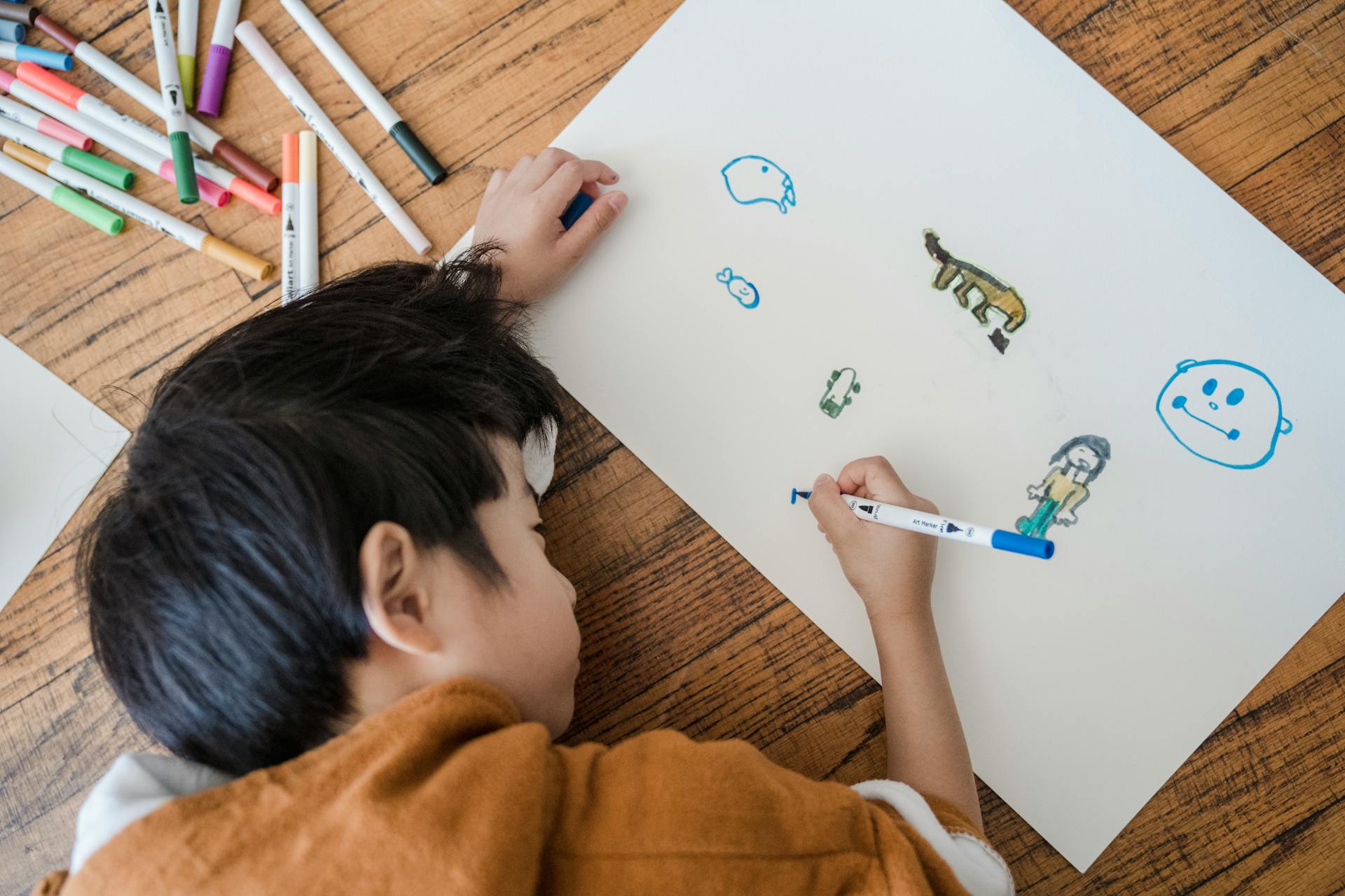 A boy drawing on a paper | Source: Pexels