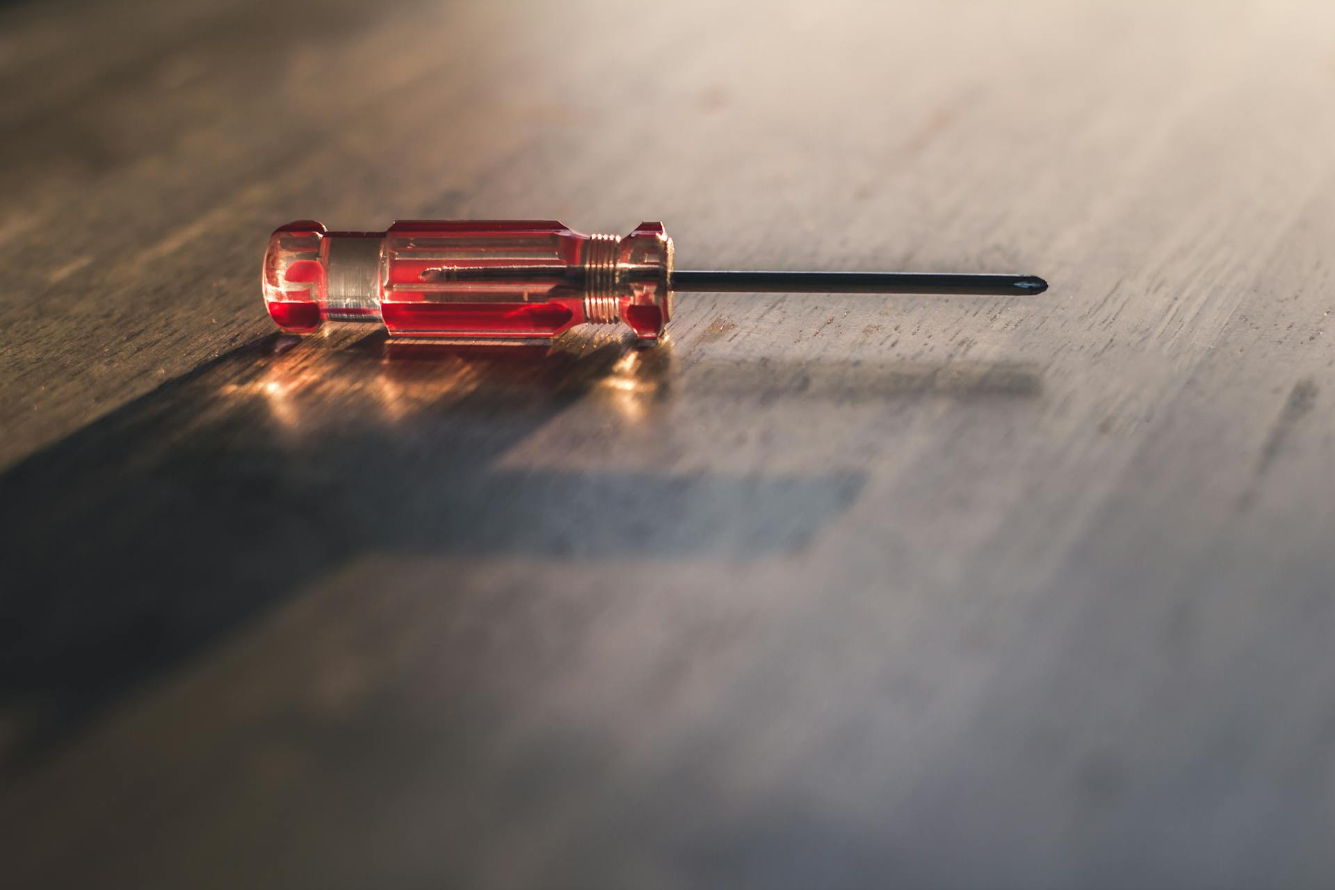 A screwdriver lying on a wooden surface | Source: Pexels