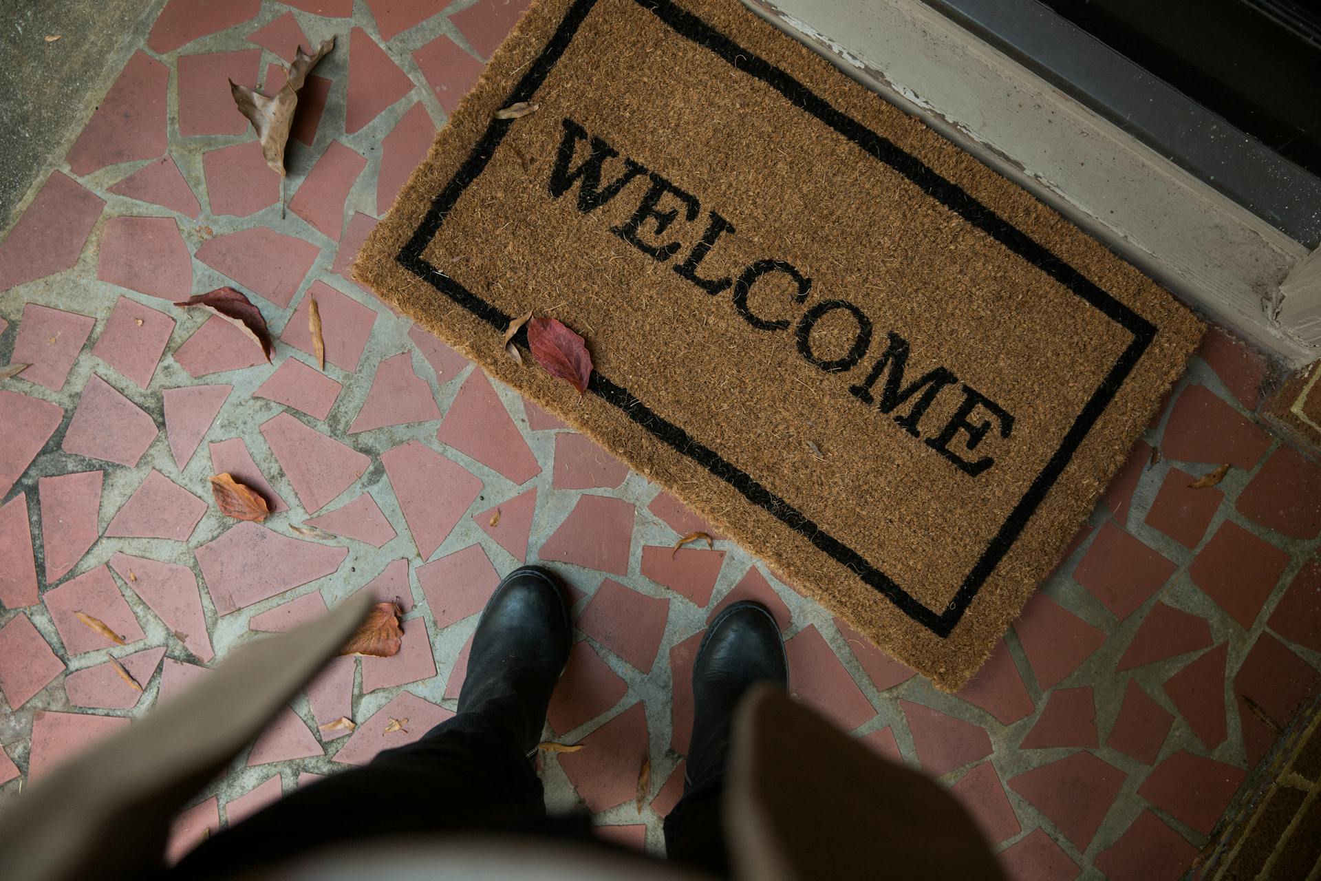 A person standing near a doormat | Source: Pexels