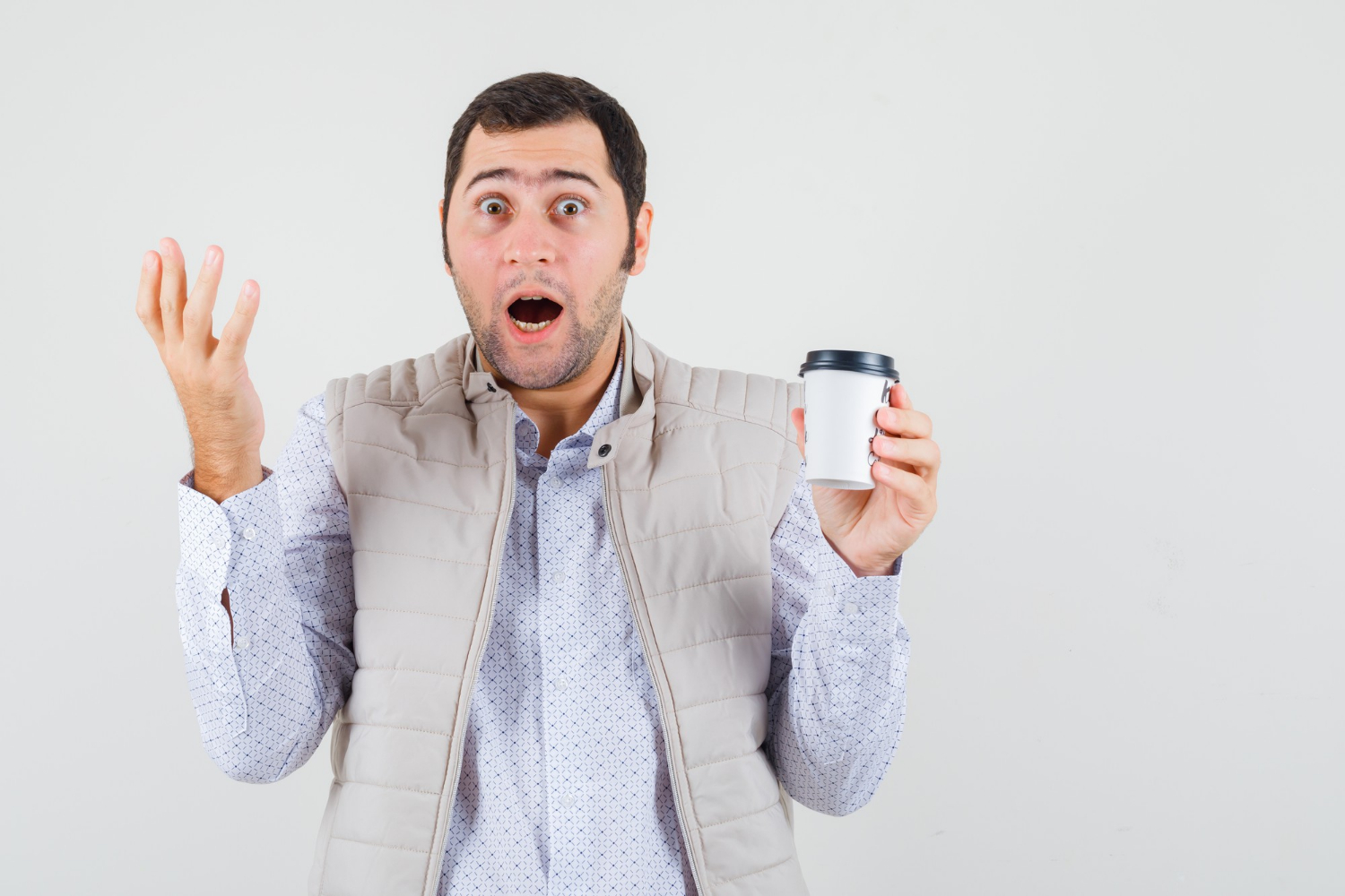 A shocked man holding a coffee cup | Source: Freepik